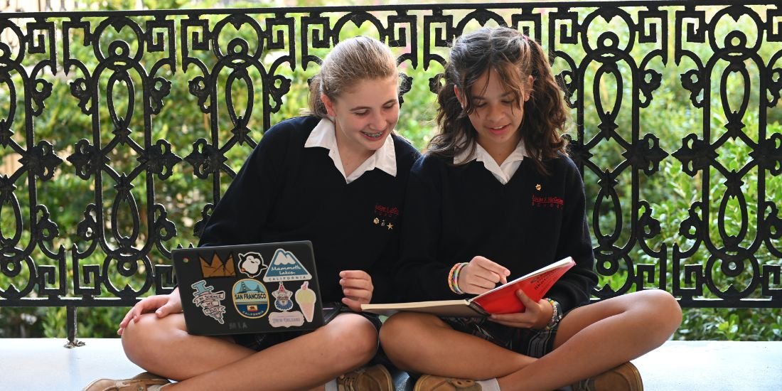 two students working on laptop